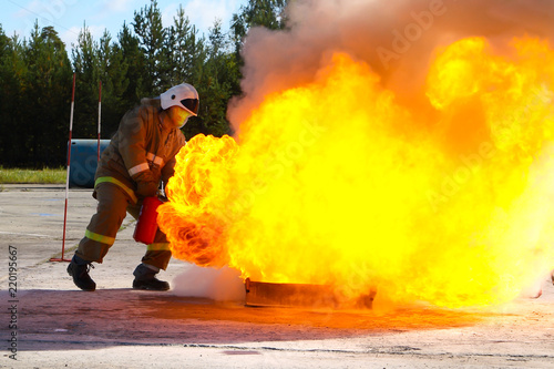 Competitions firefighters. The fireman works with a fire extinguisher to extinguish the fire.