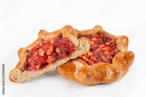 Tasty pastry of rye dough cut in half . Delicious pastries with fruit jam on light background. berry, strawberries or raspberries