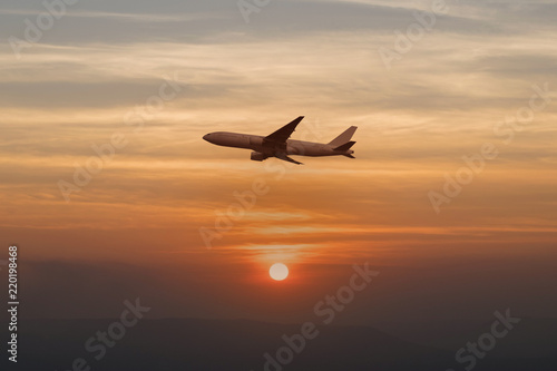 Beautiful transporation airplane is flying throught beautiful nature prime sun setting landscape warm tone background aswesome sky twilight silhouette.