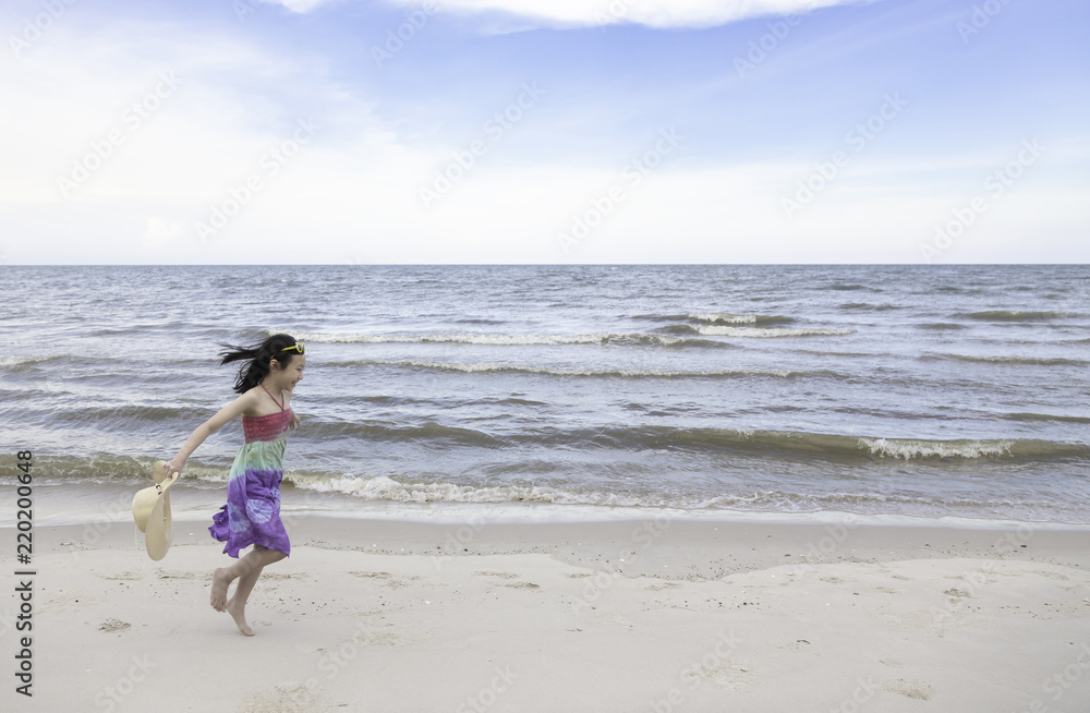 Happy little girl playing on the beach,summertime fun concept