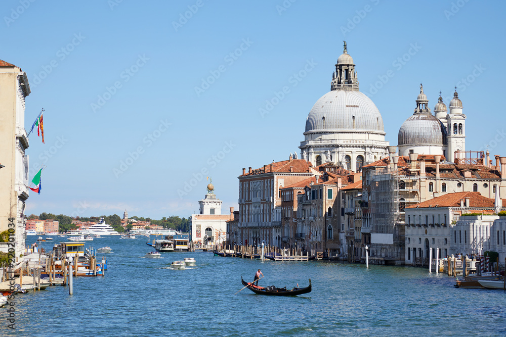 Venice, Saint Mary of Health basilica and Grand Canal with gondola in Italy in a sunny summer day