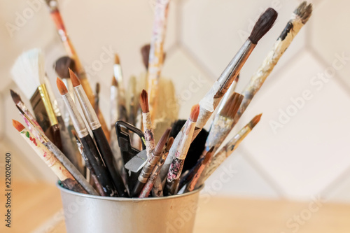 Different brushes of the artist in a metal bucket, selective focus