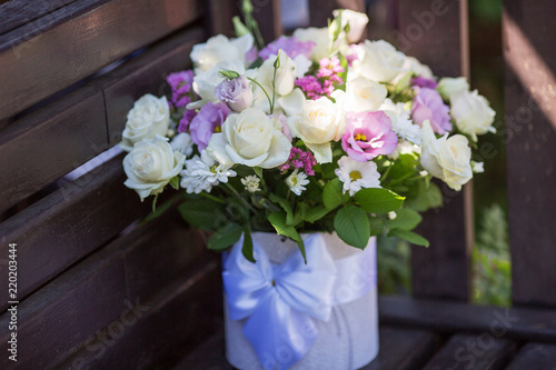a bouquet of roses for a holiday. Roses are white and lilac in a decorated box.