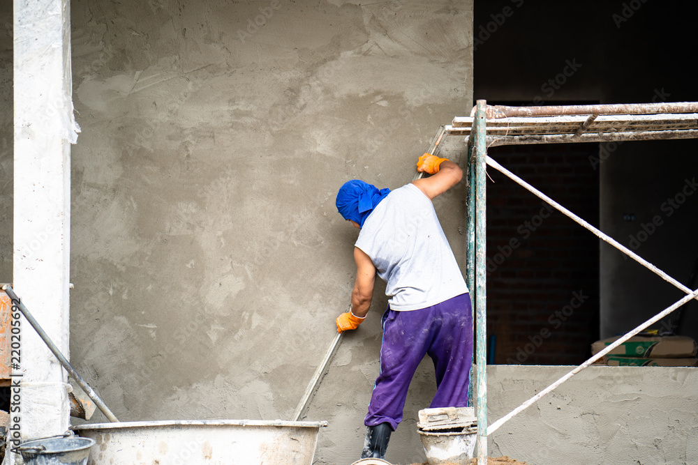 construction workers plastering building wall and beam using cement
