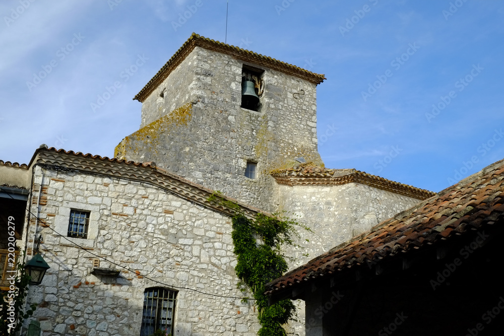 Looking up at Saint Nicholas' church in autumn sunshine in Pujols, Lot-et-Garonne, France. This historic fortified village stronghold is a member of 