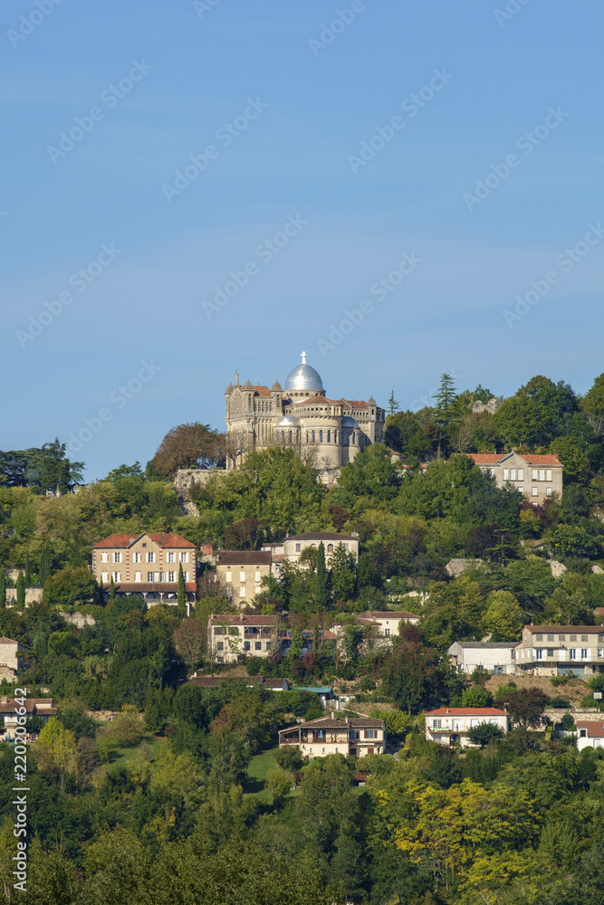 Fortified Penne d'Agenais and its hilltop Byzantine-Romanesque style Notre-Dame de Peyragude basilica with its silver dome oversses rural Agenais countryside in Lot et Garonne, France.