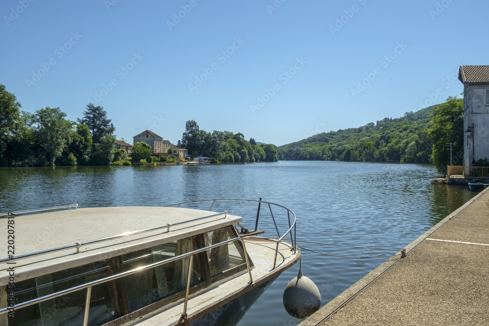 Looking along the tranquil River Lot at Port de Penne, the old river port for Penne d'Agenaise, on a beautiful sunny summer morning, Lot et Garonne, France