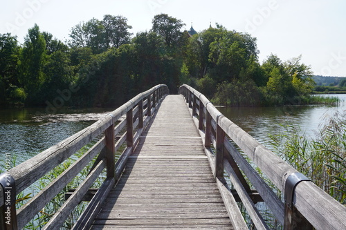 Fototapeta Naklejka Na Ścianę i Meble -  Holzbrücke für Fußgänger über See auf Insel
