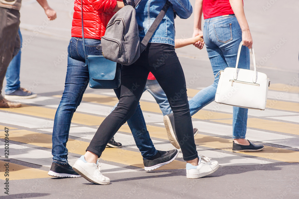 legs of people crossing the pedestrian crossing in the busy street legs of people crossing the pedestrian crossing in the busy street