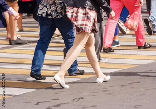 legs of pedestrians in a crosswalk on summer day