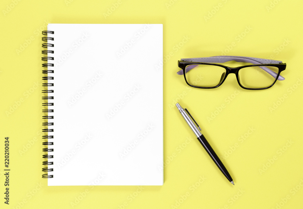 Mock up notebook, pen and glasses on colorful background with copy space.view from above