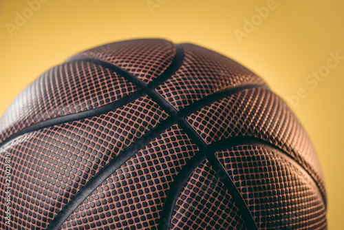close up of brown basketball ball isolated on yellow