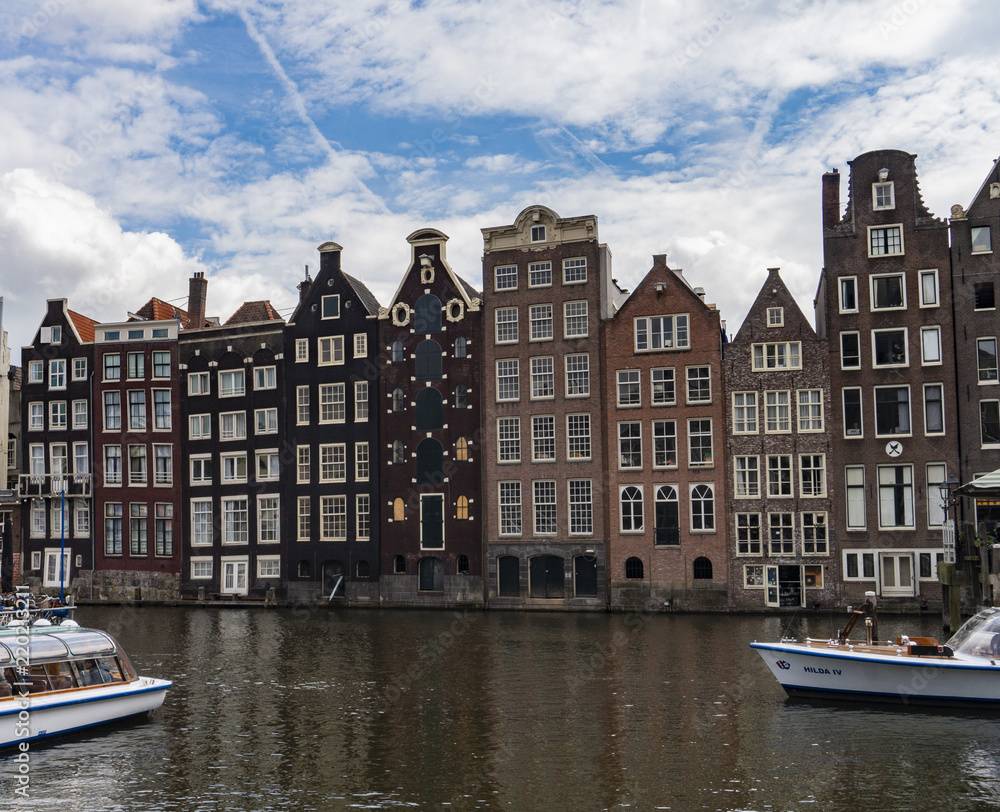 Row of authentic canal houses and touboats in Amsterdam, Netherlands
