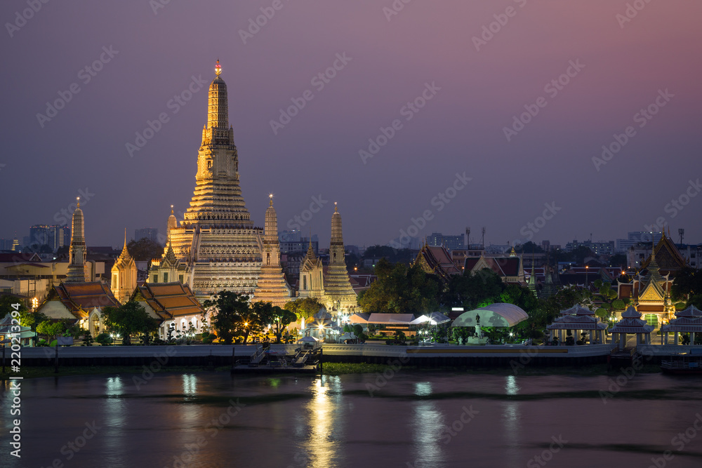 Beautiful view of lit Wat Arun temple next to Chao Phraya River in Bangkok, Thailand, at dusk. Beautiful view of lit Wat Arun temple next to Chao Phraya River in Bangkok, Thailand, at dusk.