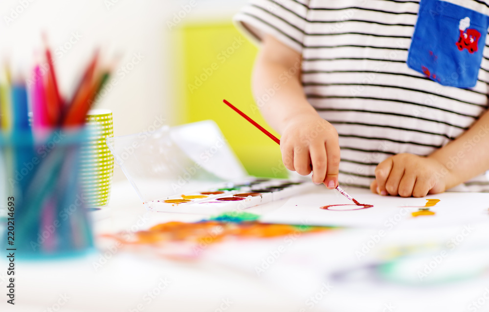 Little child drawing on the paper in room Little child drawing on the paper in room