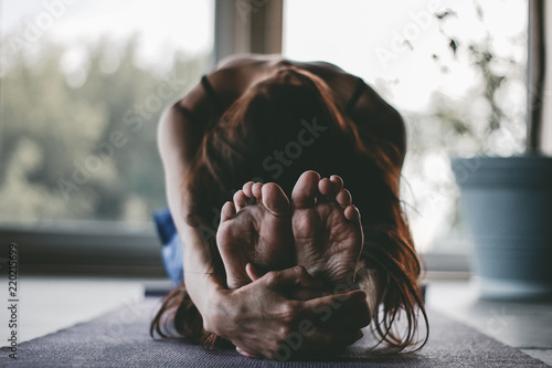 Woman in Yoga Pose practice stretching pilates movement relaxing in home class interior indoors with plant