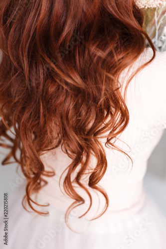  Long-haired girl with curly red hair. Hair falls from the shoulders. Hair up to priests.
