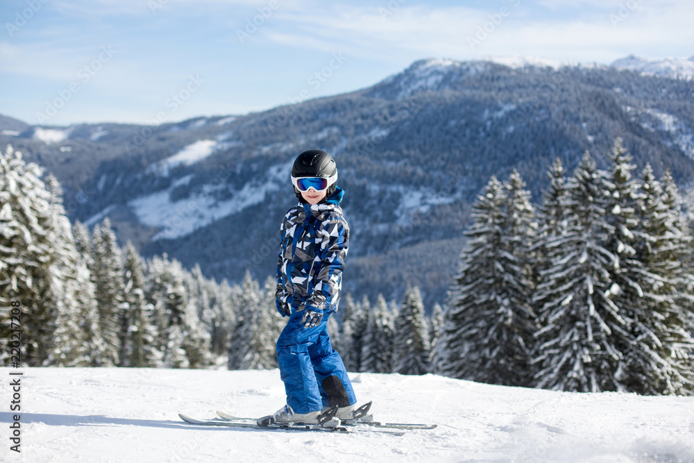 Cute preschool child, skiing in Austrian winter resort on a clear day