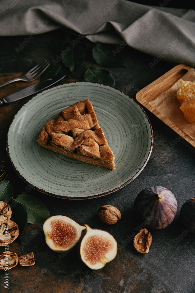close up view of fresh figs and homemade pie on plate on dark grungy tabletop close up view of fresh figs and homemade pie on plate on dark grungy tabletop