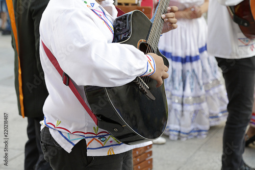 Man playing the guitar and wearing one of the traditional costume of the Republic of Nicaragua