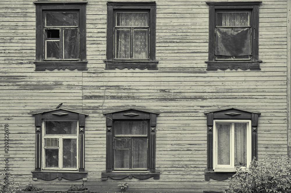 Old wooden house facade with six beautiful windows