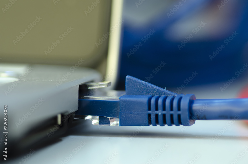 Closeup ethernet cable connected to the Lan port on laptop for computer network concept Closeup ethernet cable connected to the Lan port on laptop for computer network concept
