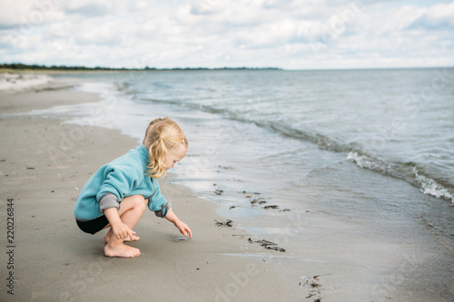 2 year old picking up a little jelly fish