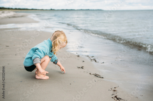2 year old picking up a little jelly fish