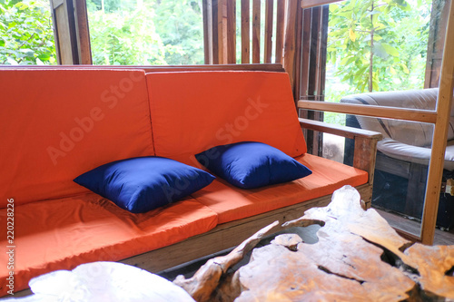 Orange sofa Color and wooden table in garden.