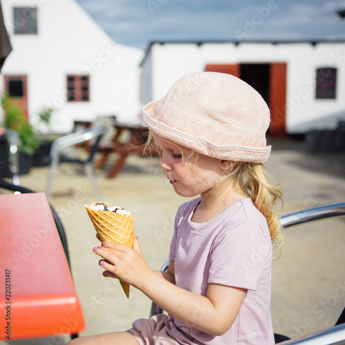 Happy girl eating a bit ice cream cone