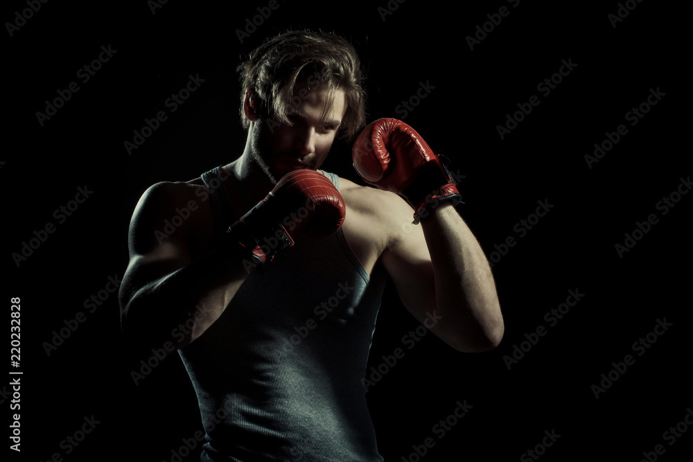 Boxing, young boxer on black background. Sexy guy in red sports gloves. Sport concept