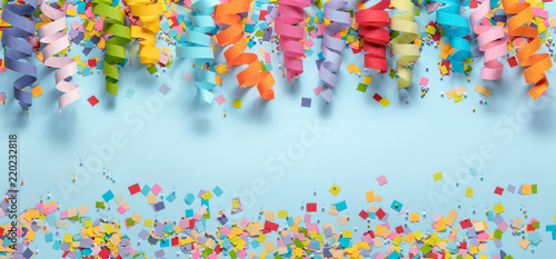 Streamers and confetti on blue background.Birthday decoration.