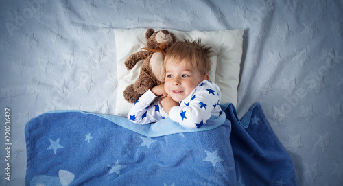 three years old child sleeping in bed