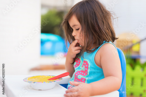 Cute little girl eating puree