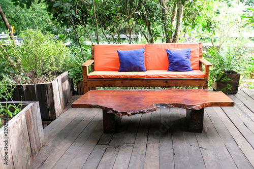 Orange sofa Color and wooden table in garden.
