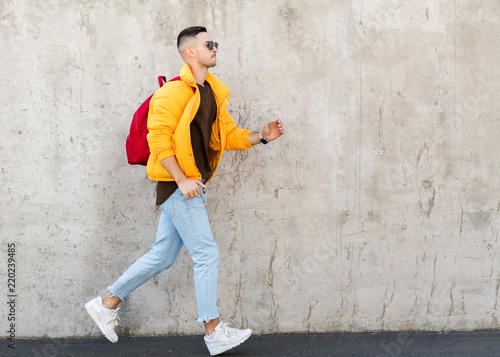 fashion guy standing near a concrete wall in yellow clothes