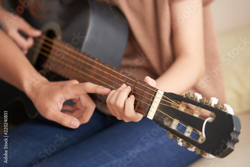 Cropped image of young woman attending acoustic guitar class