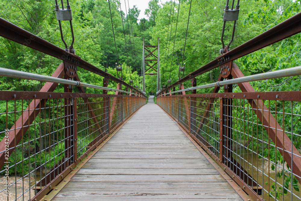 Suspension bridge in the middle of the forest over the a river Suspension bridge in the middle of the forest over the a river