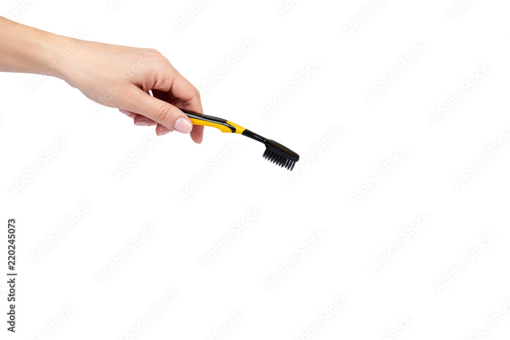 Black and yellow soft toothbrush with hand isolated on white background, copy space template Black and yellow soft toothbrush with hand isolated on white background, copy space template