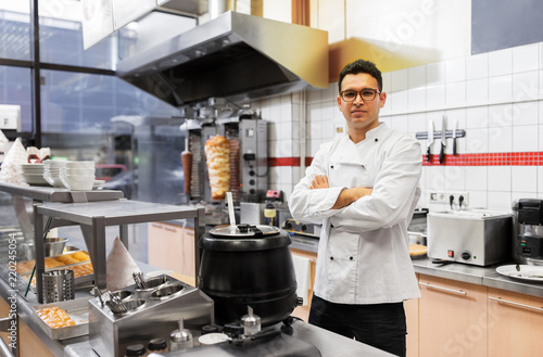people, fast food and cooking concept - chef at kebab shop