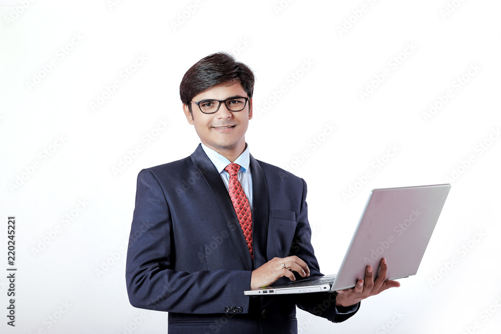 Young Indian businessmen using laptop over isolated background.