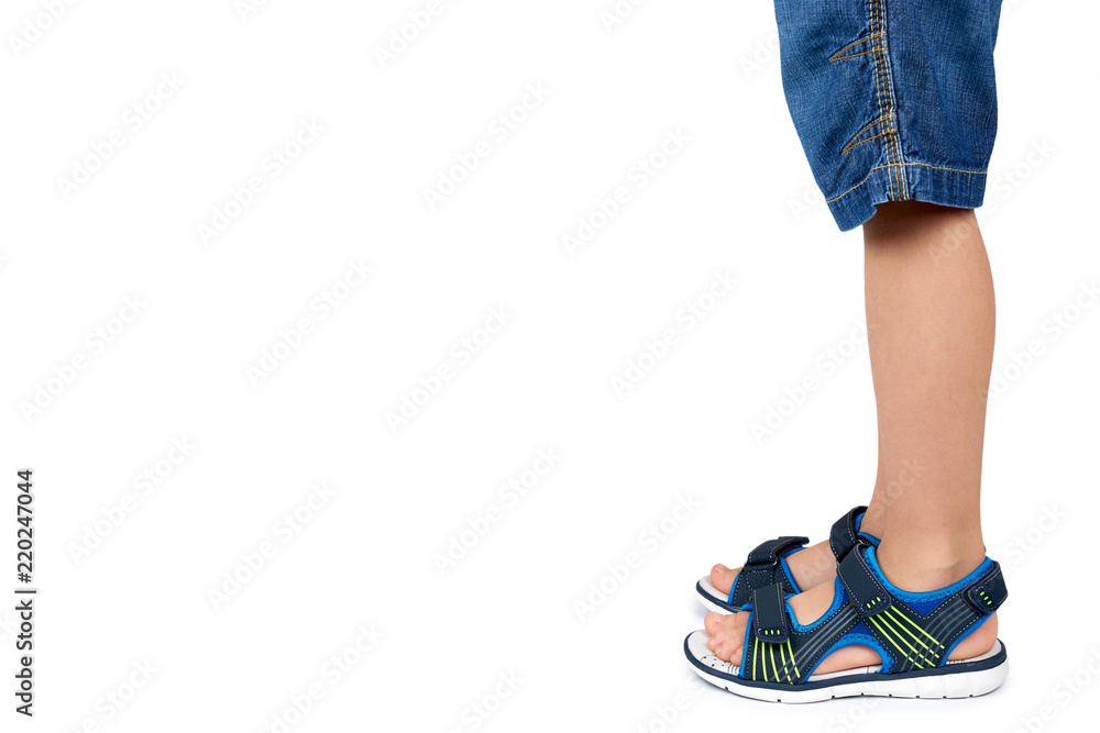 Kids leather sandals on leg isolated on a white background, copy space template