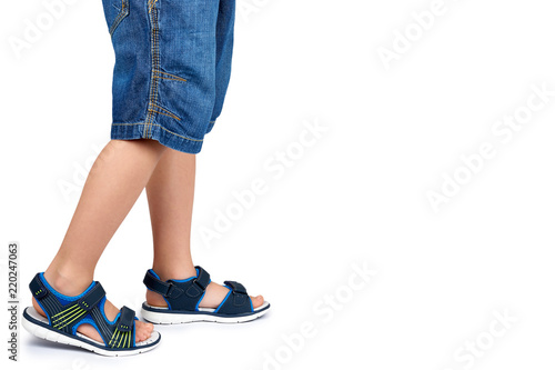 Kids leather sandals on leg isolated on a white background, copy space template