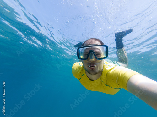 Male diver taking a selfie while snorkling.