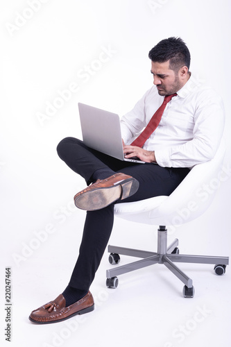 Businessman sitting on white chair isolated.