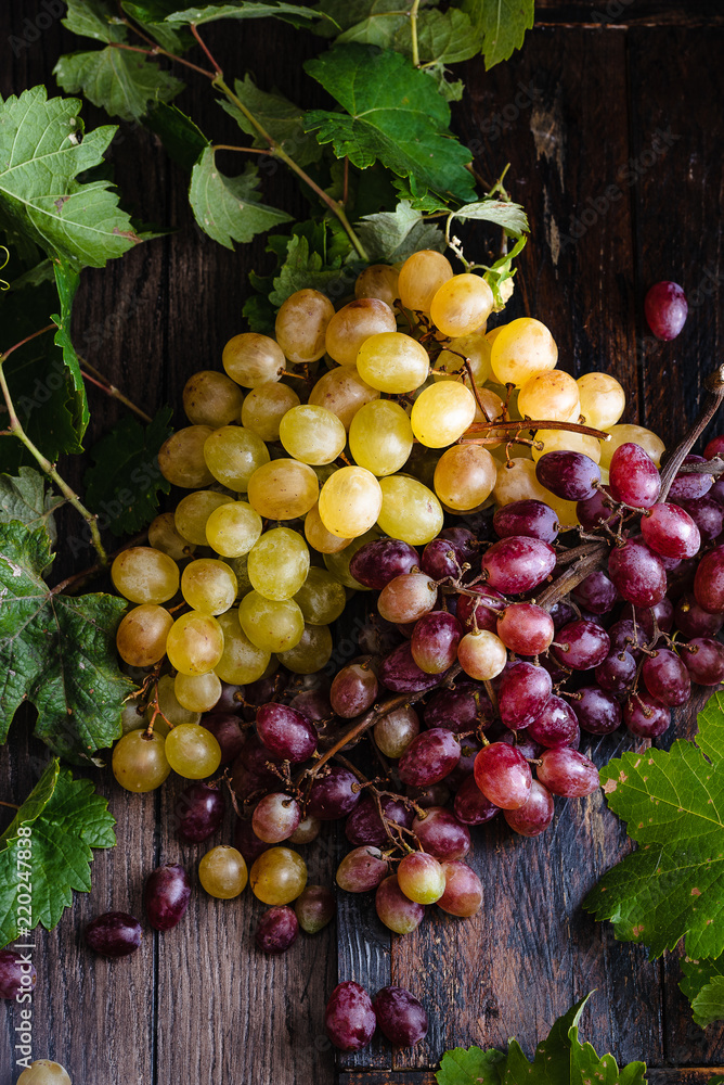 bunches of white and red grapes on a rustic base bunches of white and red grapes on a rustic base
