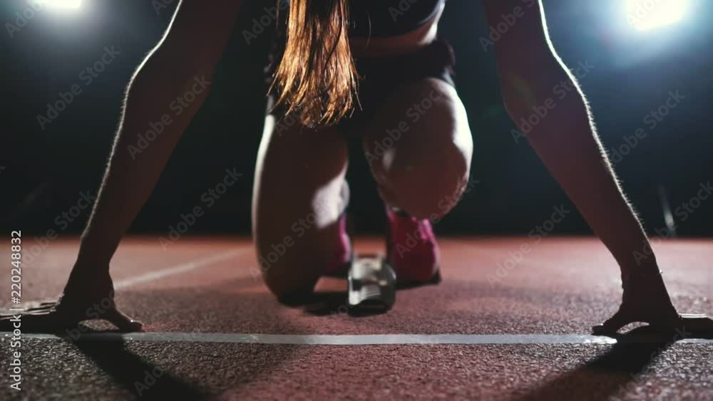 Close-up legs in sneakers athletes are running pads on the track of the sports complex and run in slow motion