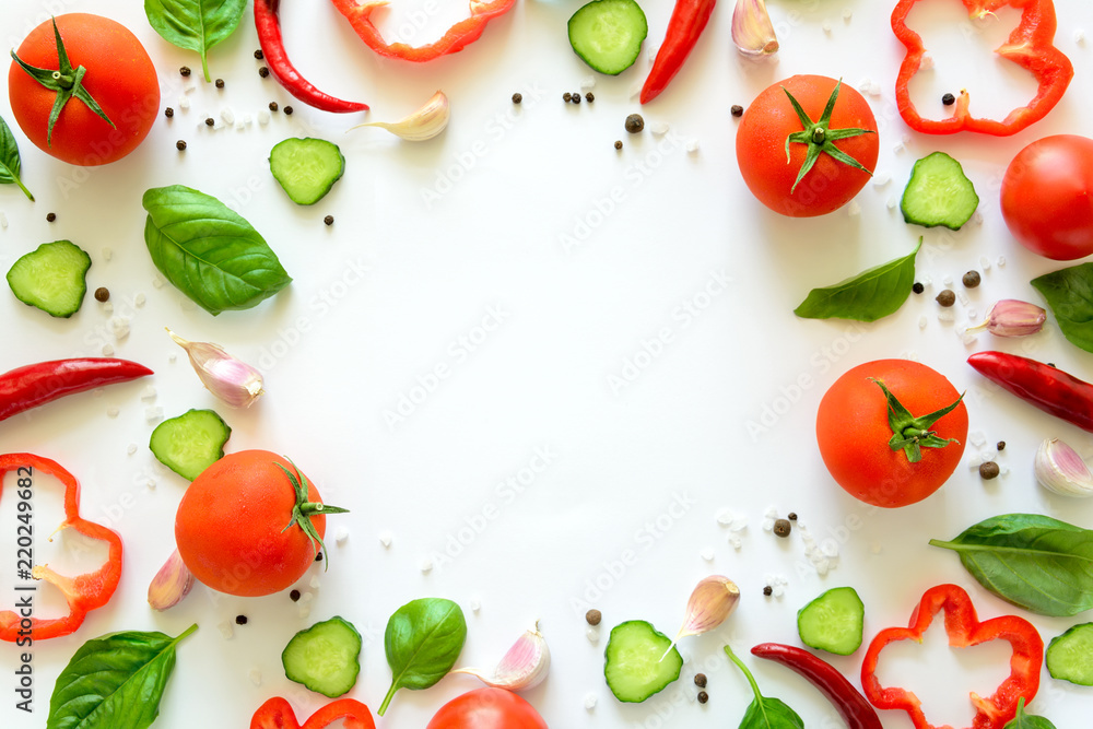 Colorful salad ingredients pattern made of tomatoes, pepper, chili, garlic, cucumber slices and  basil on white background. Cooking concept. Top view. Flat lay. Copy space