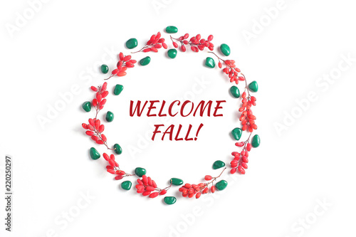 Quote: "welcome fall!". Frame of red berries on a white background. Simple flat lay composition, autumn creative background