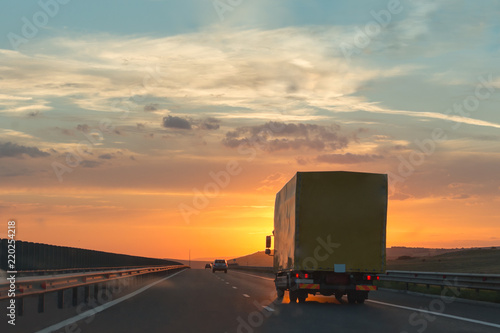 Truck and cars on the highway at sunset